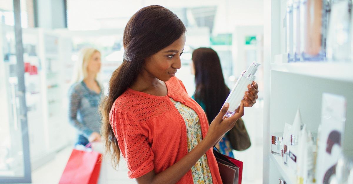 woman examining skincare product in drugstore