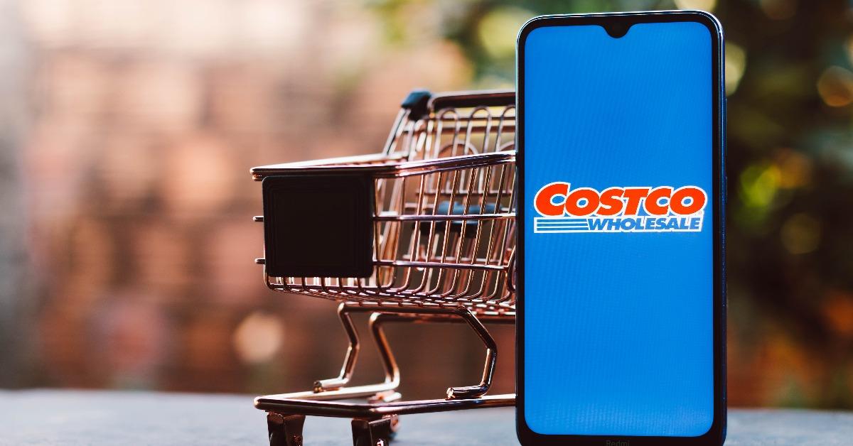 Costco Wholesale Corporation logo displayed on a smartphone along with a shopping cart