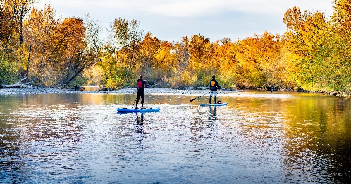 people use paddle boards to get down the Boise River in autumn 