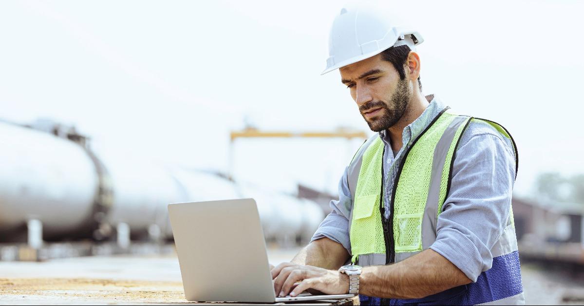 industrial engineer stands in a pipeline manufacturing facility using digital tablet