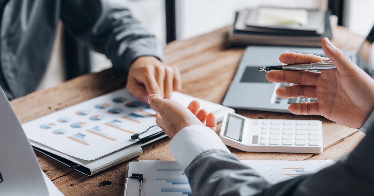 businessmen are reviewing monthly sales documents for analysis 