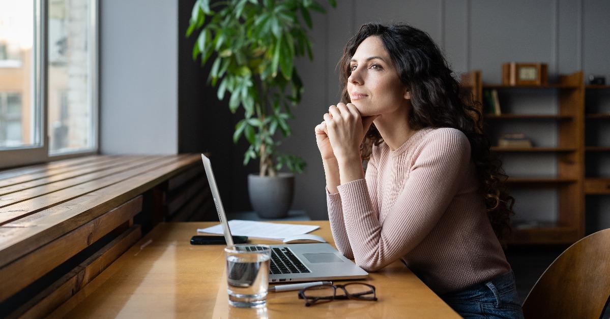 smiling female entrepreneur thinking about business goals 