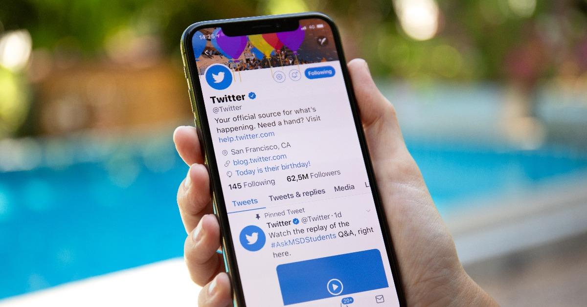 woman hand holding iPhone X with social networking service Twitter