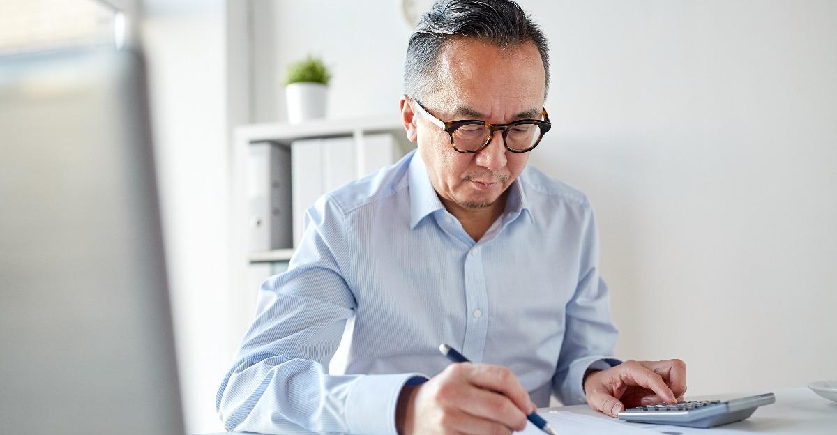 businessman with calculator and papers at office