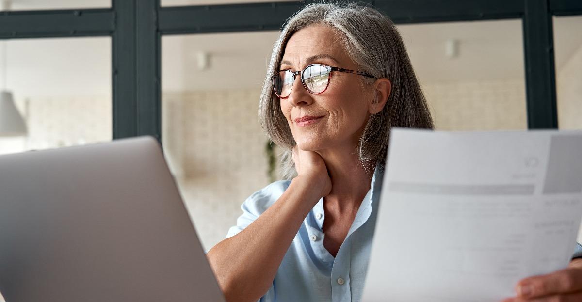 senior woman using laptop working on computer sitting at desk