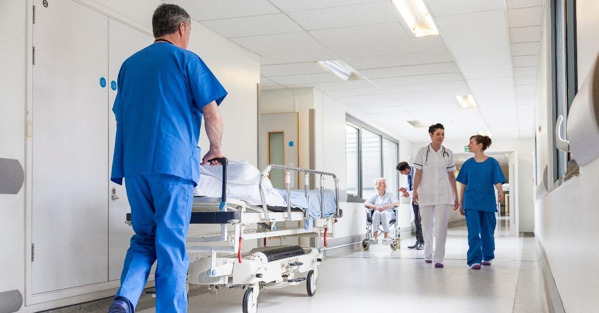 hospital corridor with nurse pushing gurney stretcher bed