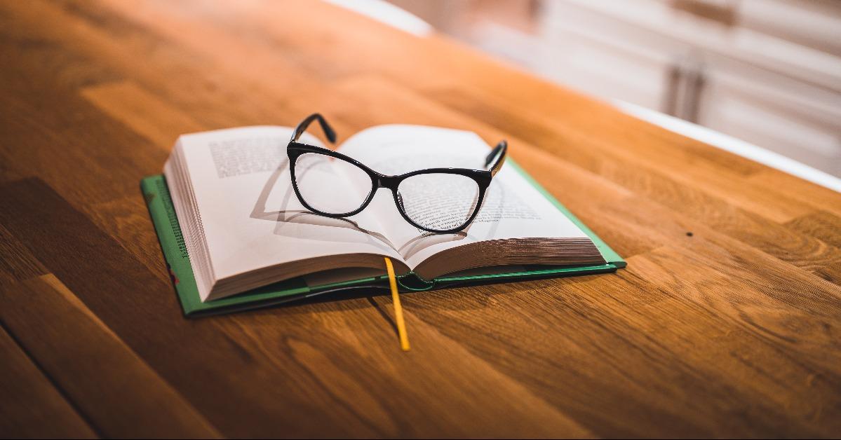open book and glasses on table