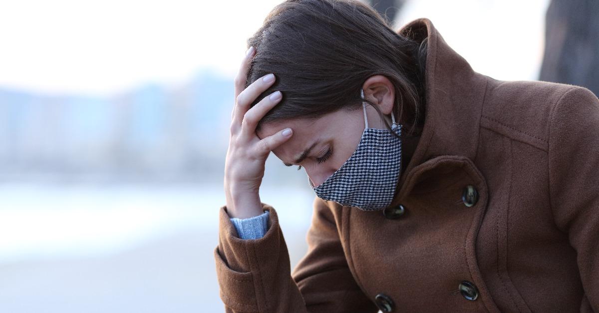 sad woman with mask complaining in covid days
