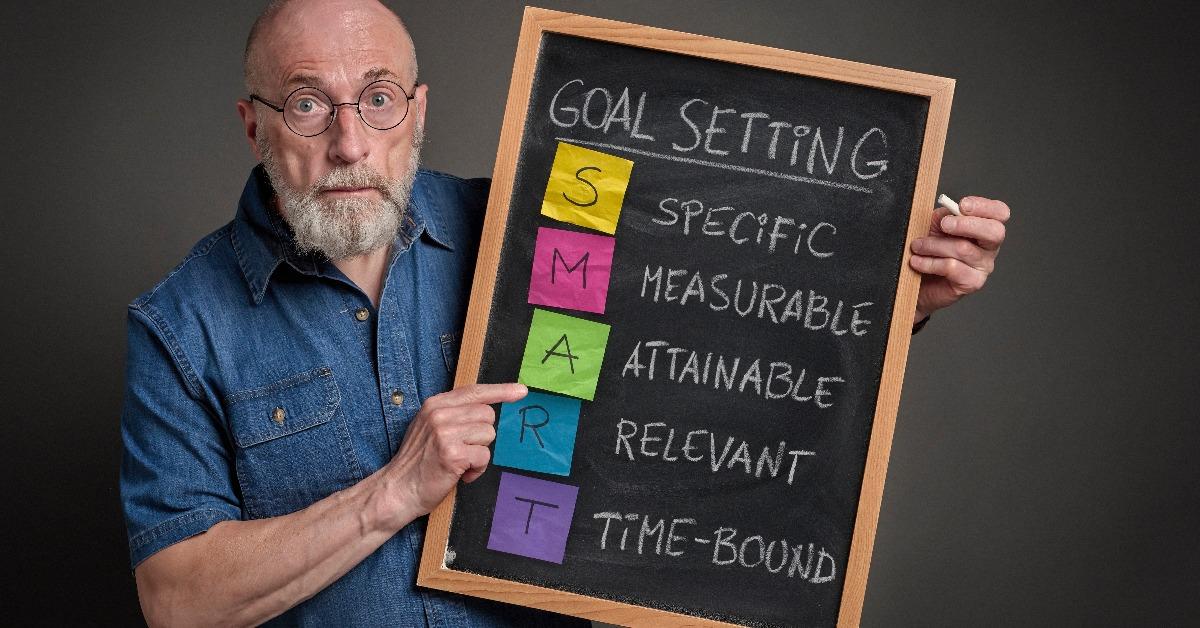 senior man is sharing goal setting methodology on a blackboard