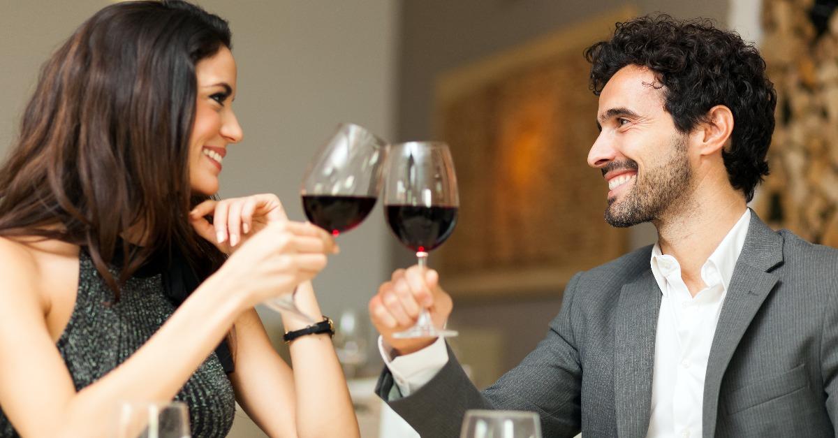 couple toasting wine glasses in a restaurant