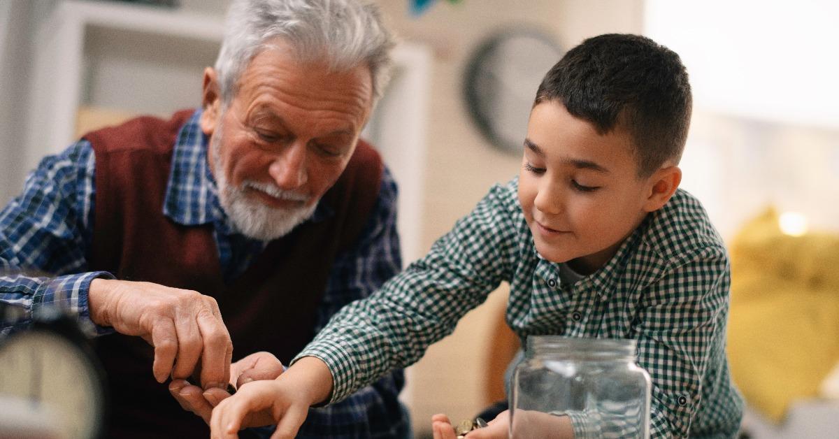 grandfather teaching grandchild how to save money