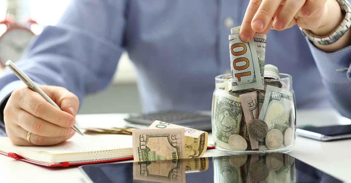 male hand depositing some extra money in future