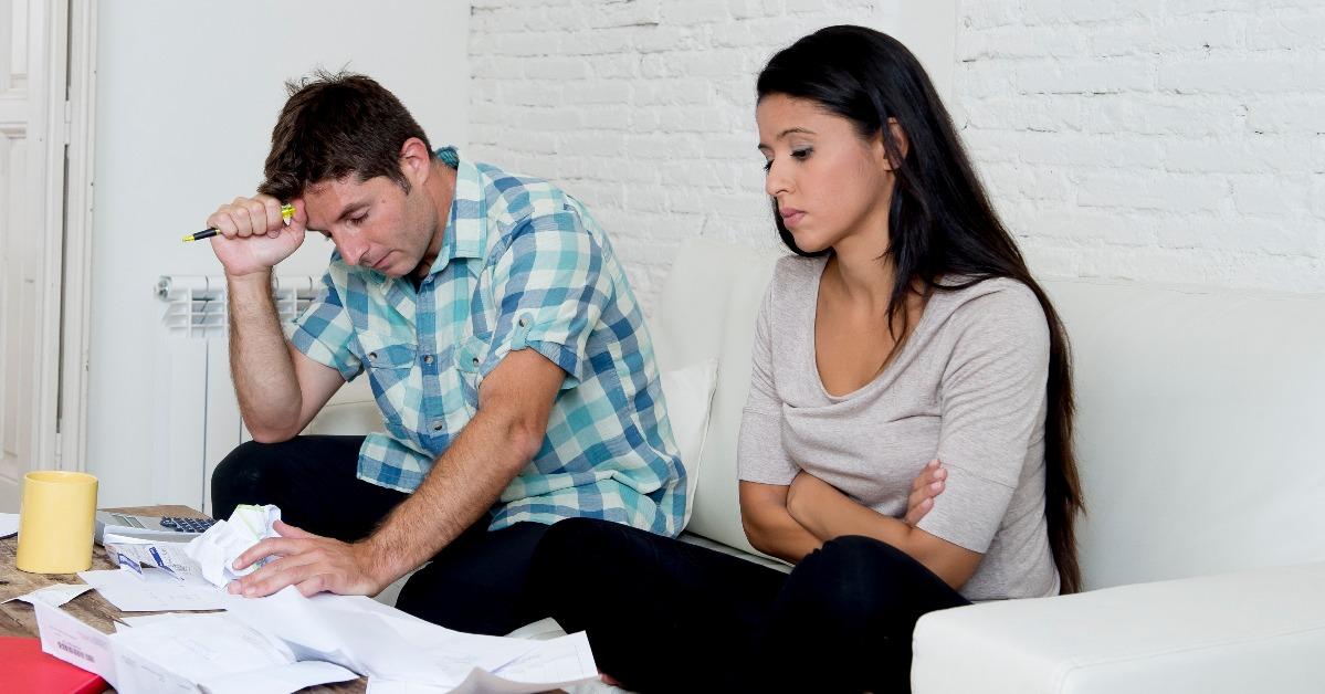sad couple calculating monthly expenses