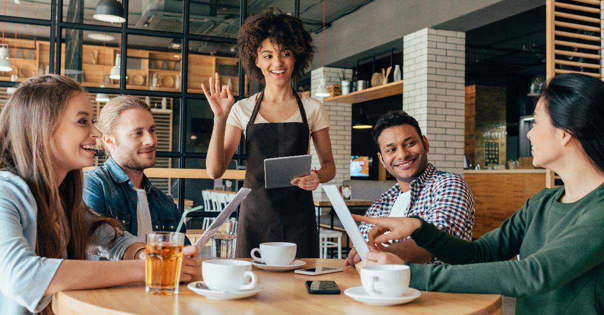 waitress taking orders from clients in cafe