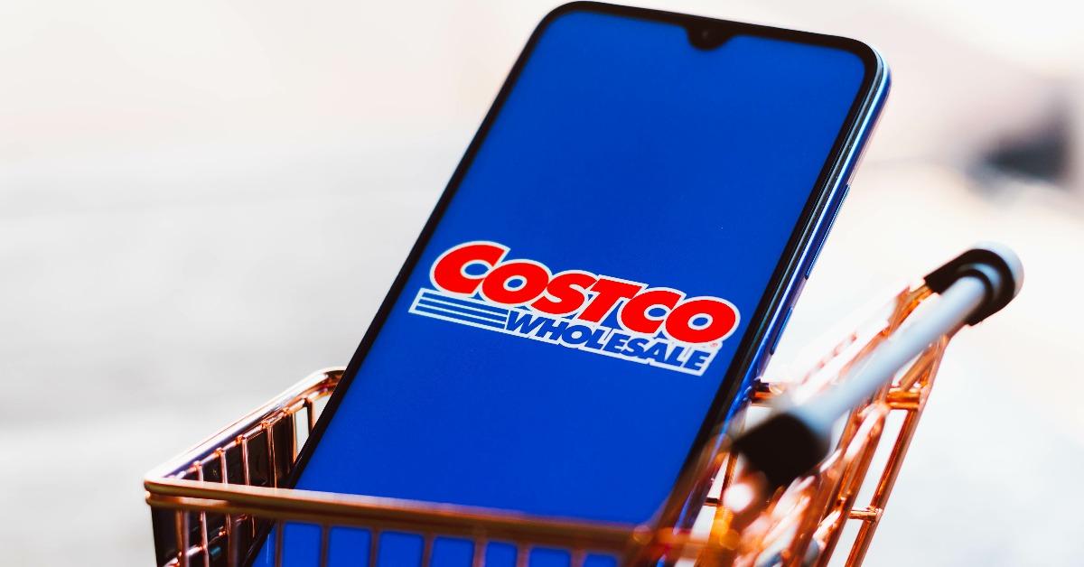 Costco Wholesale Corporation logo displayed on a smartphone along with a shopping cart