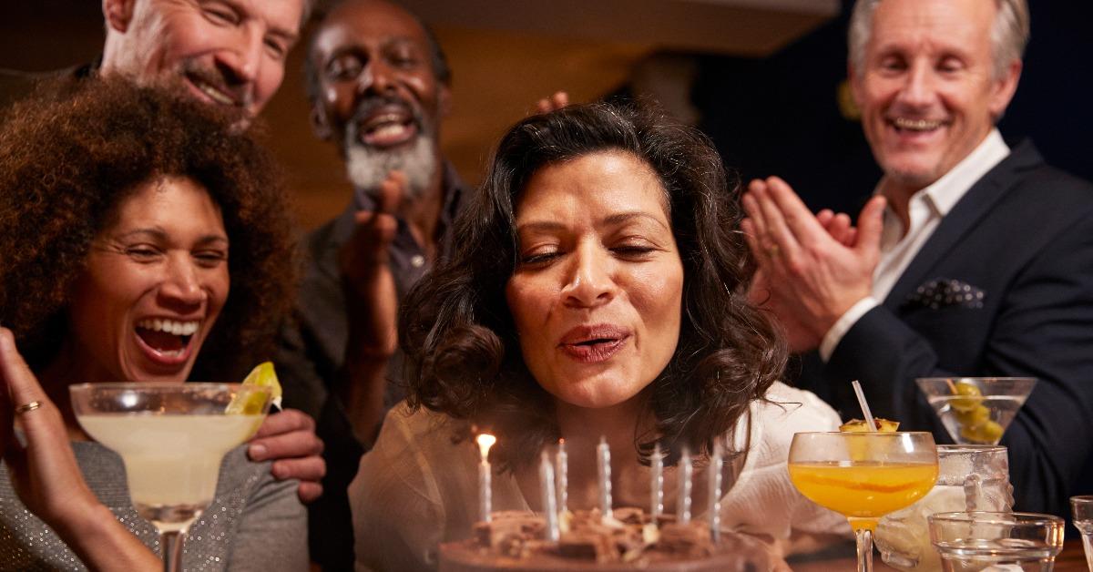group of middle aged friends celebrating birthday in bar