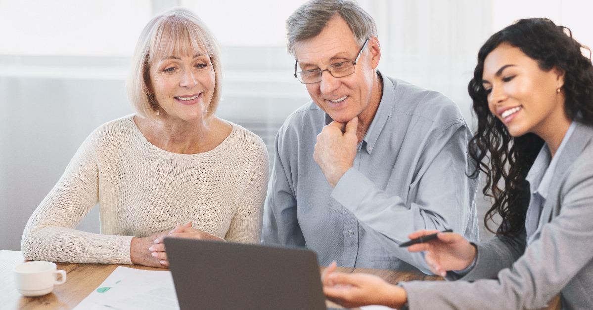 travel agent offering tour to happy elderly couple