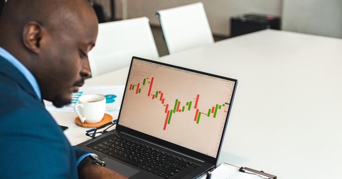 businessman works at laptop with stock market trading terminal