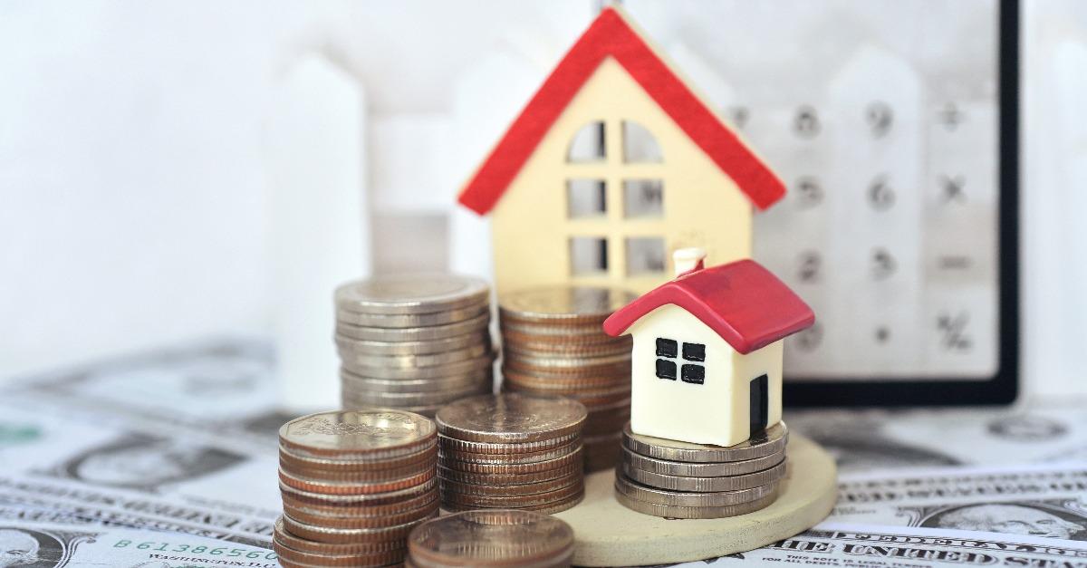 red roof house on the stacking coins around with the dollar bills