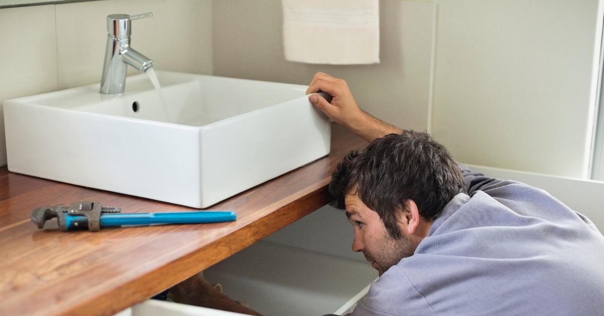 plumber working under kitchen sink