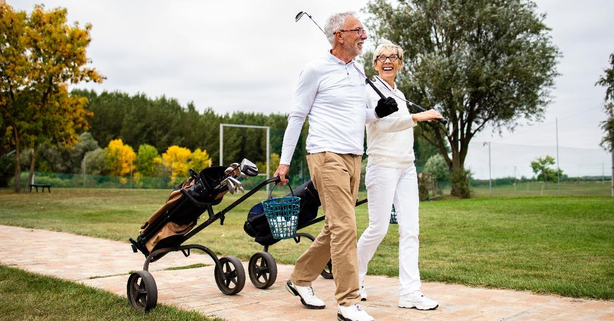 senior couple enjoying free time in retirement by playing golf
