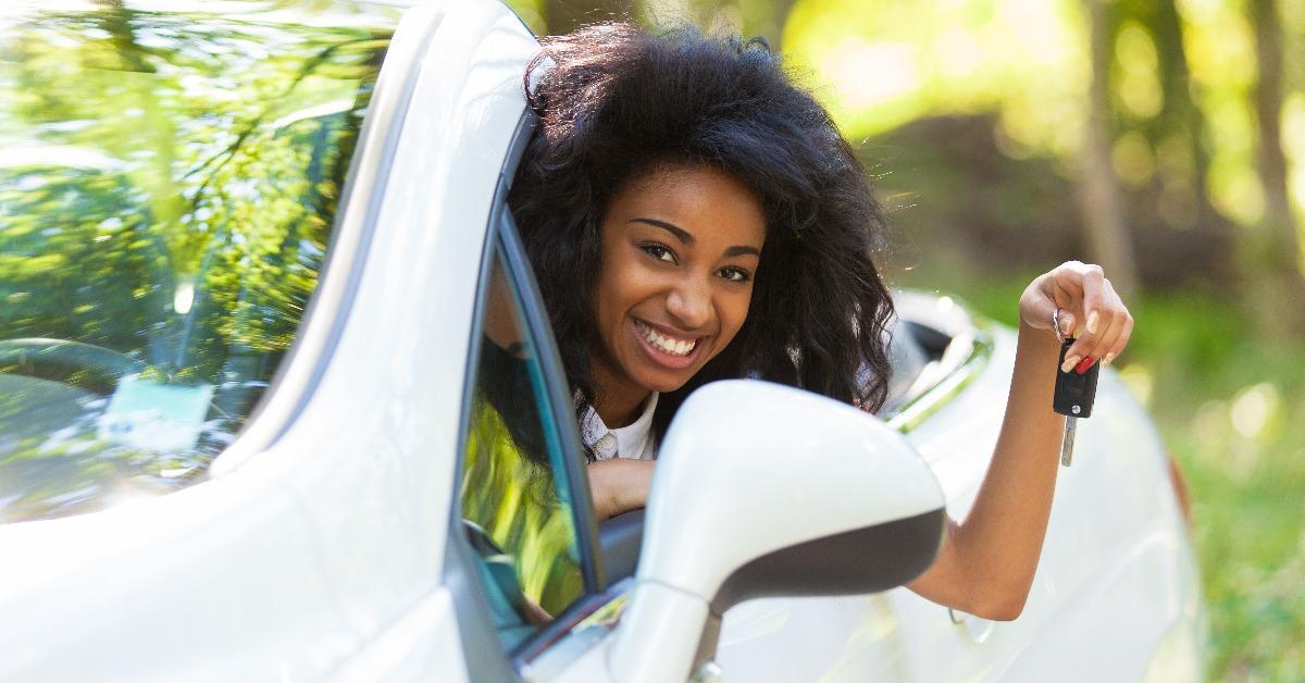 teenage driver holding car keys driving her new car