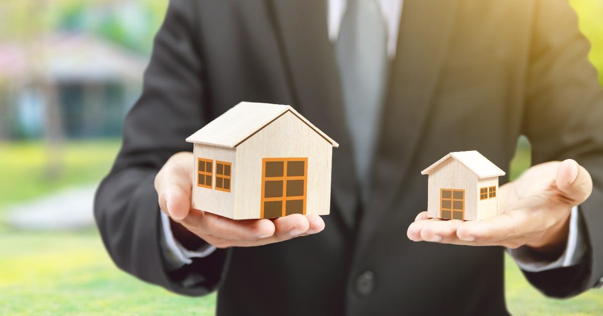 businessman hold big and small houses on hand