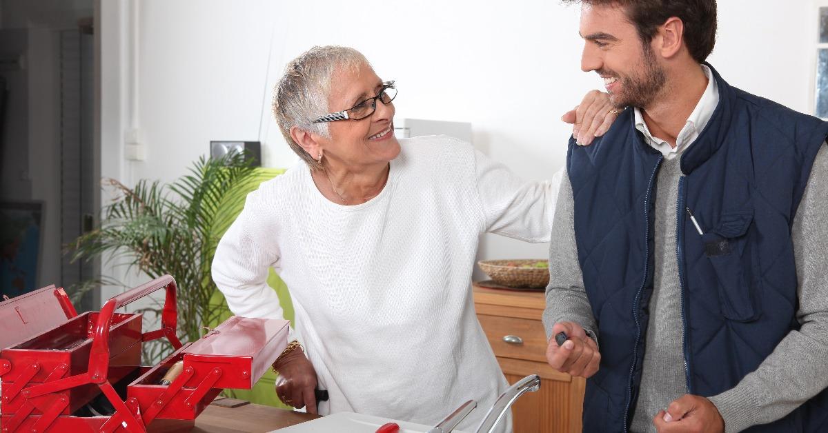 plumber repairing sink for old lady