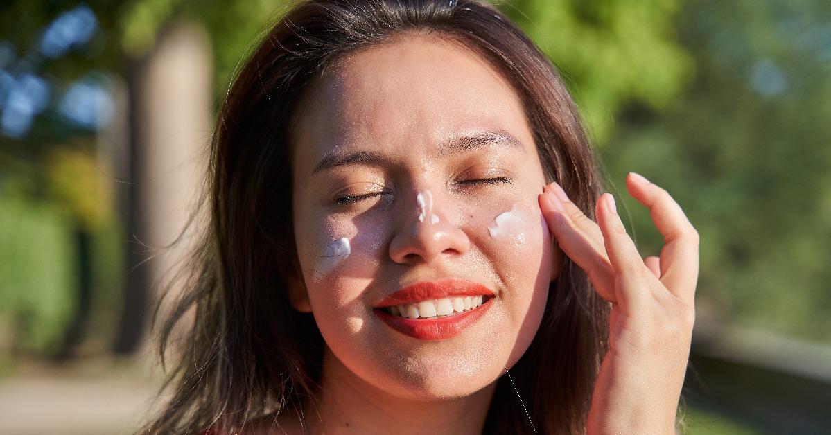 woman putting sunscreen on her face