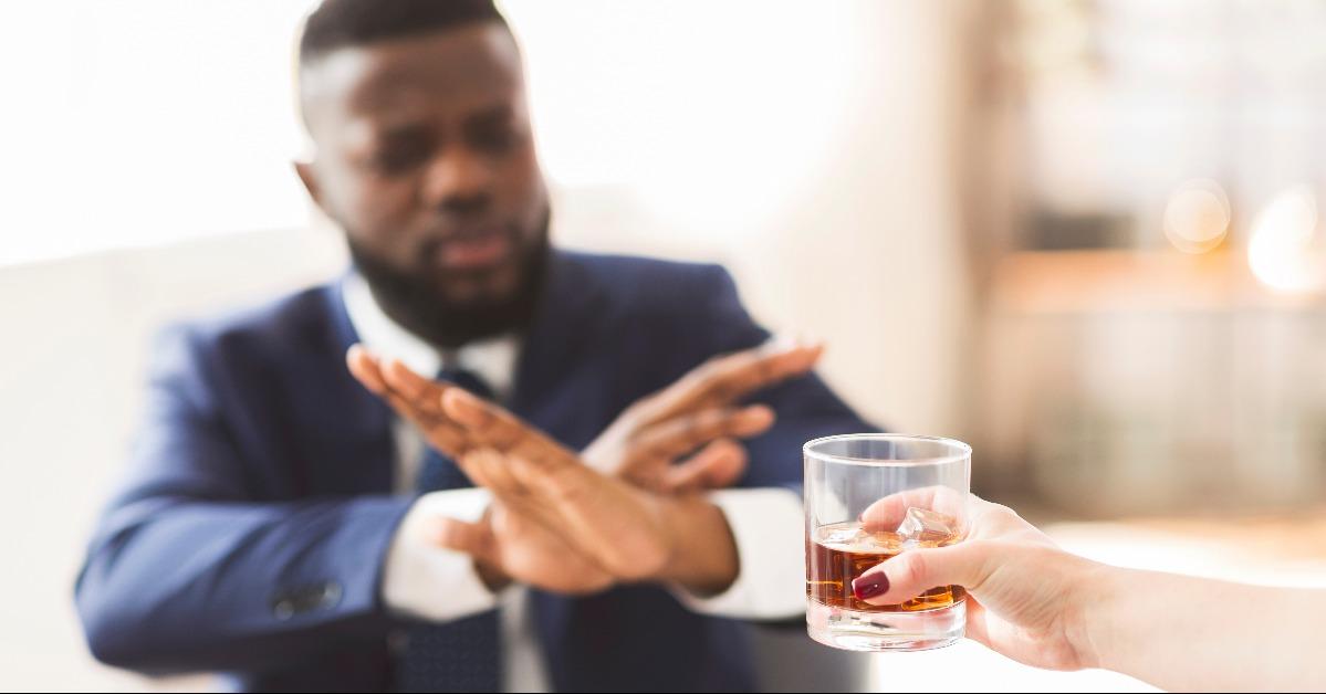 businessman showing no sign to glass of whiskey