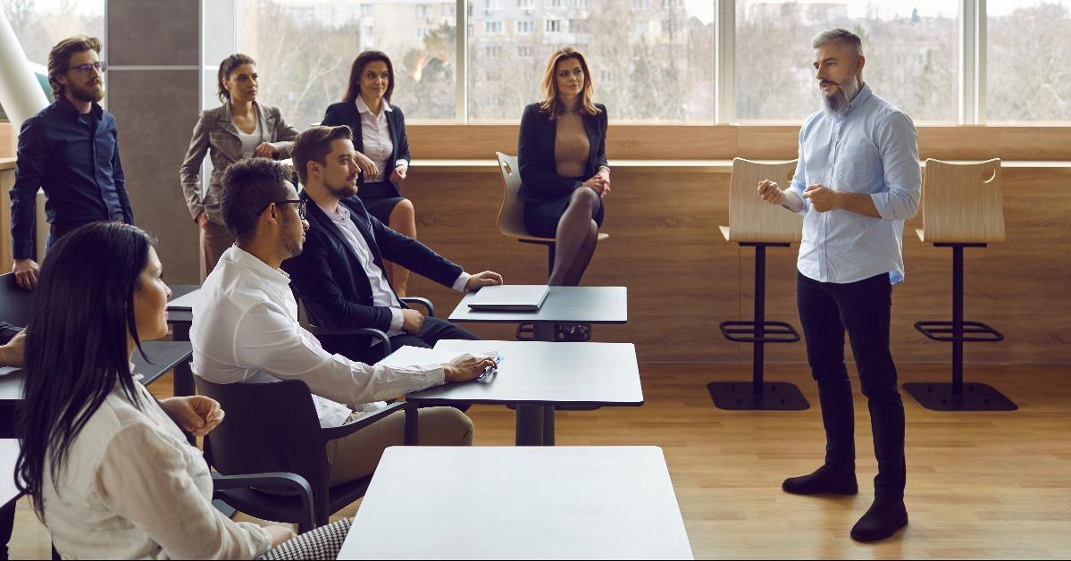 man speaker talks in front of employees at team seminar 