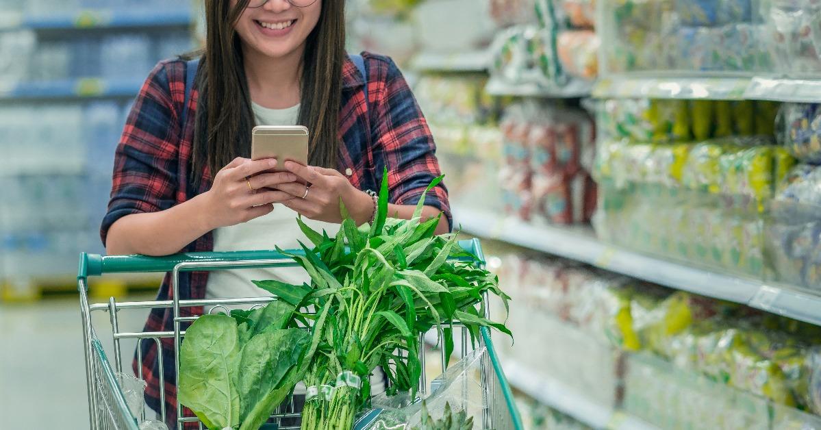 woman using smart mobile phone while shopping