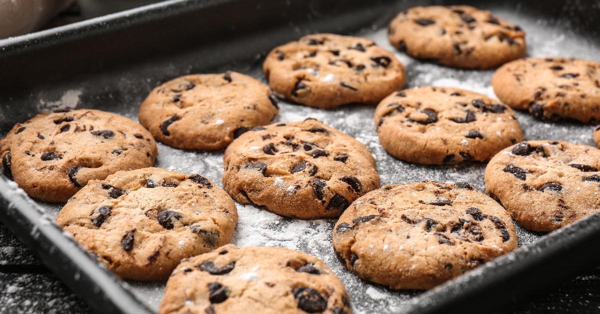tasty cookies with chocolate chips on baking tray