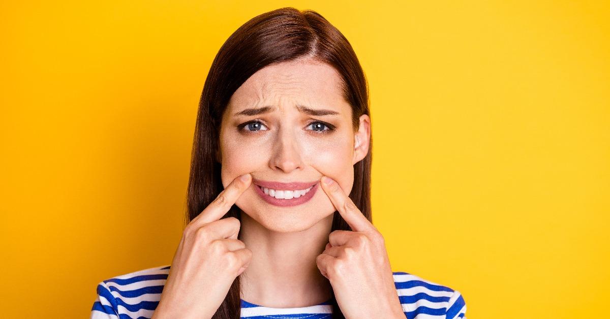 woman makes face with toothy smile