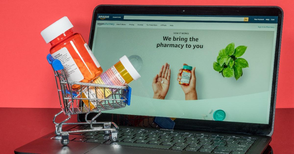 miniature shopping cart holding prescription drugs in front of screen