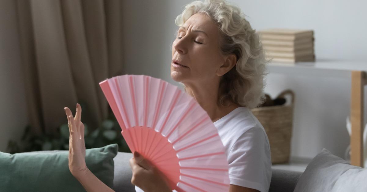  woman using orange paper fan