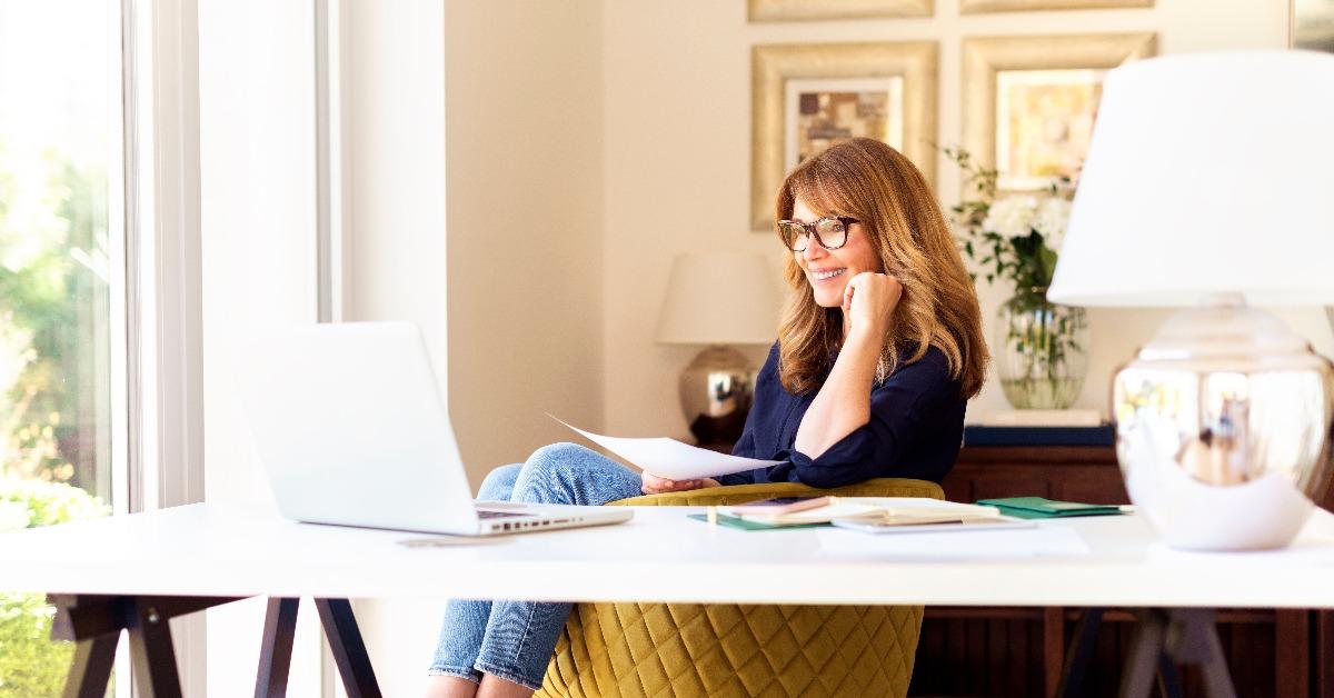 woman sitting at desk and using laptop while working at home