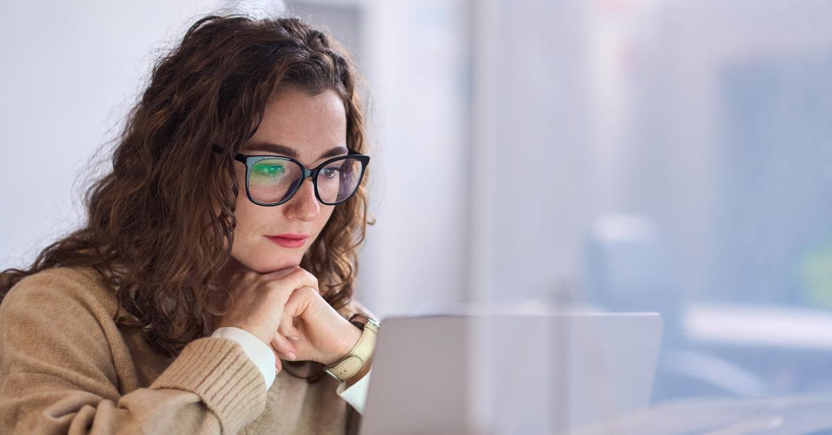 student wearing glasses using laptop