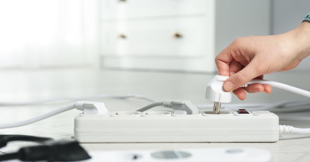 woman inserting power plug into extension cord