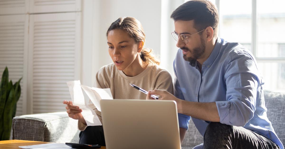 young couple manage finances paying bills online