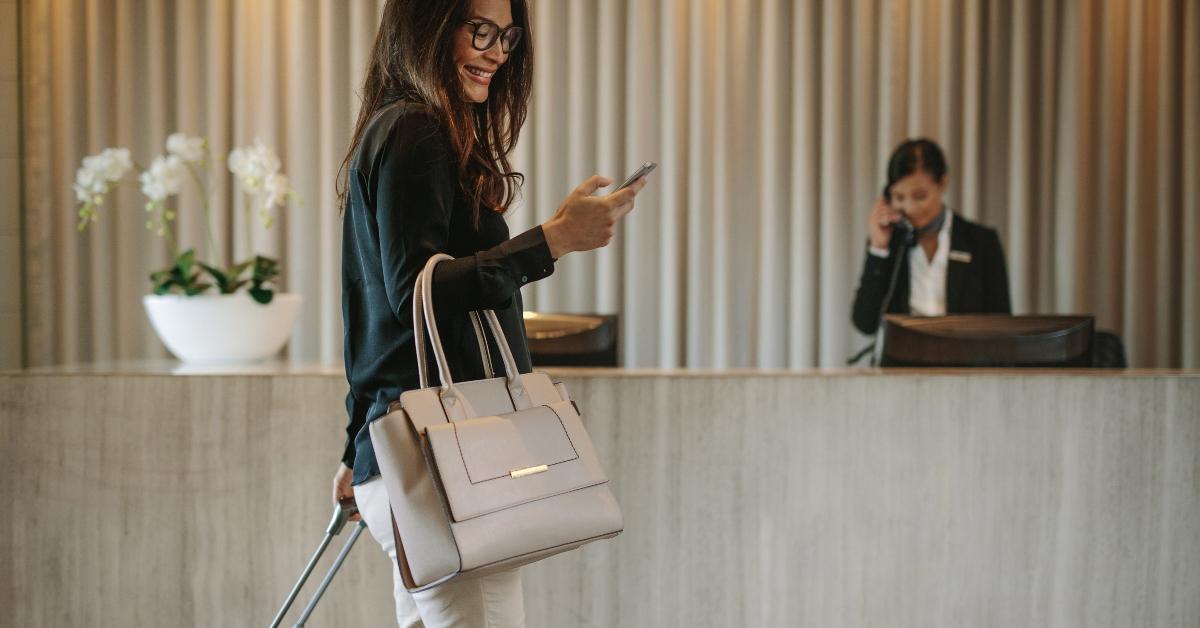 business traveler in hotel hallway with phone