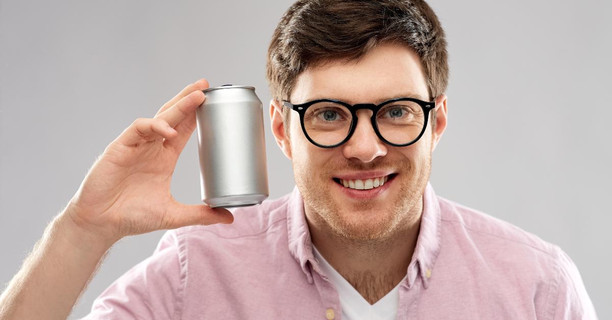 young man in glasses holding tin can