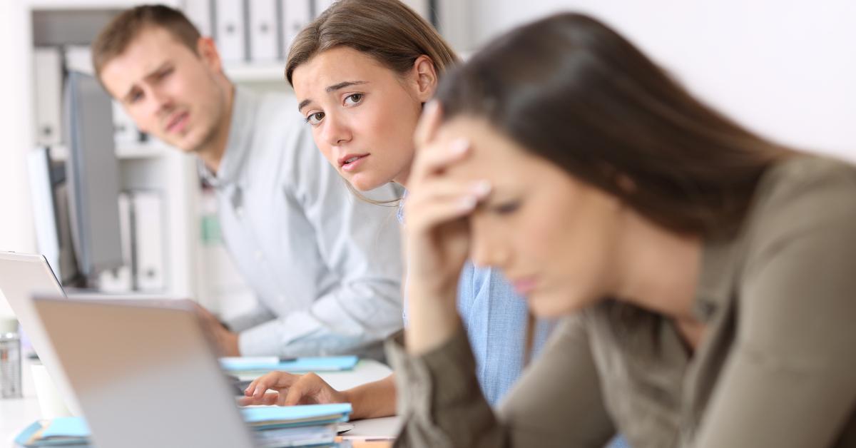 sad workers looking at a frustrated colleague