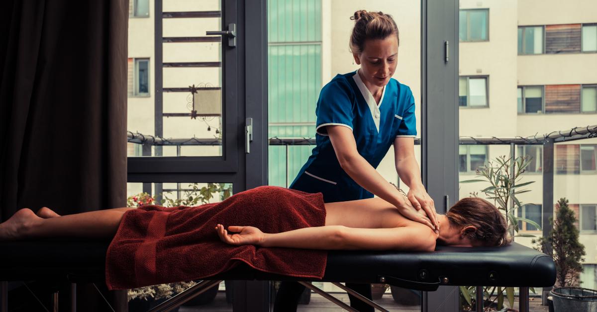 massage therapist treating patient at home
