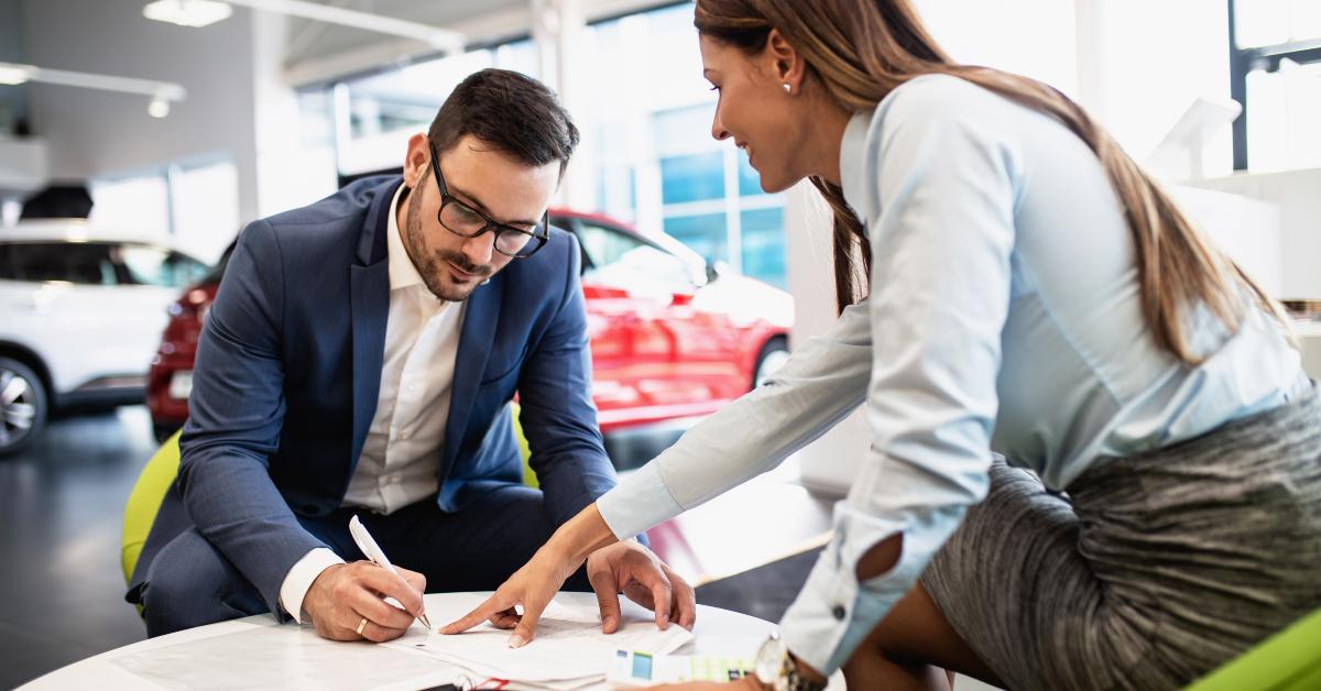 man buying a new car in a car showroom