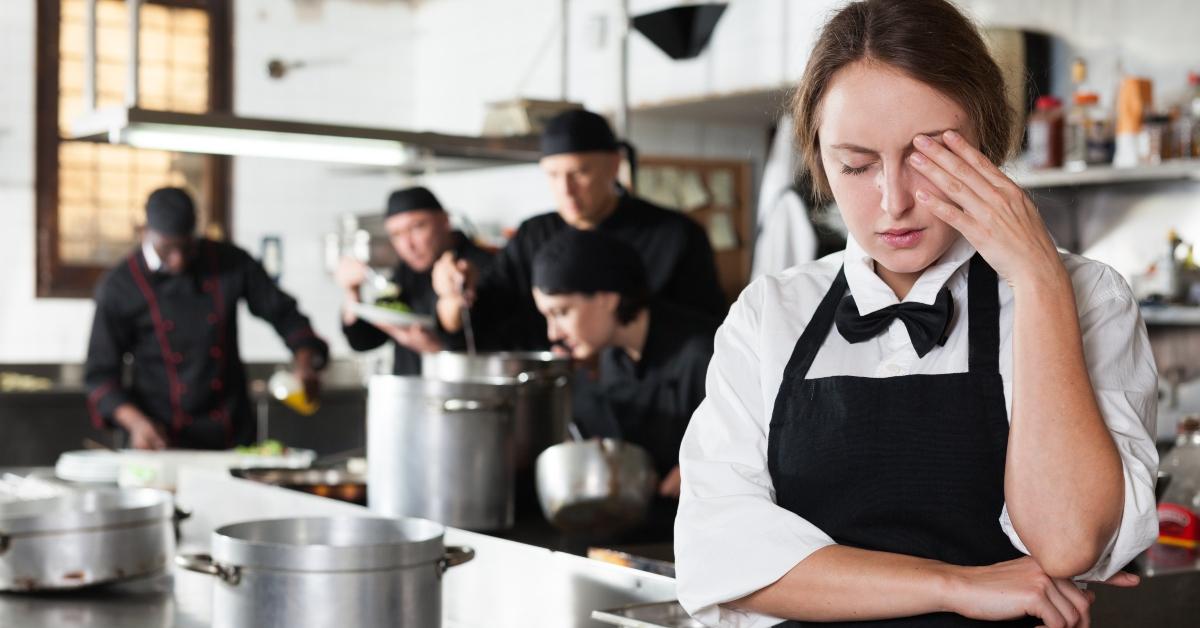 tired and upset waitress in kitchen of restaurant