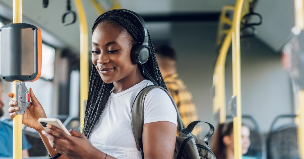 woman riding a bus and using a smartphone and headphones