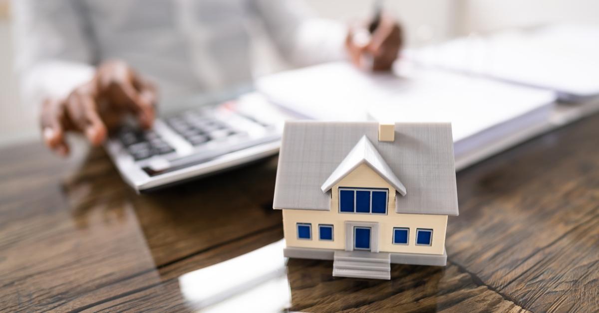 house model with man behind calculating