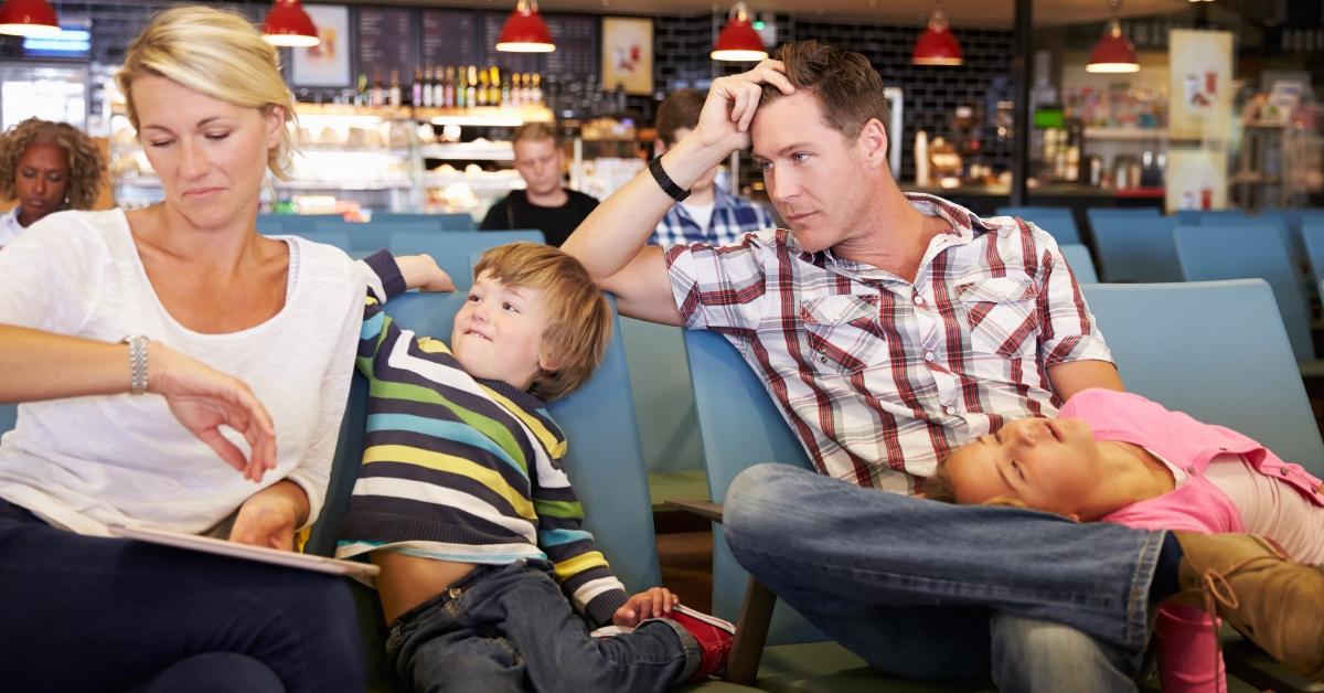 family in airport departure lounge wait for delayed flight