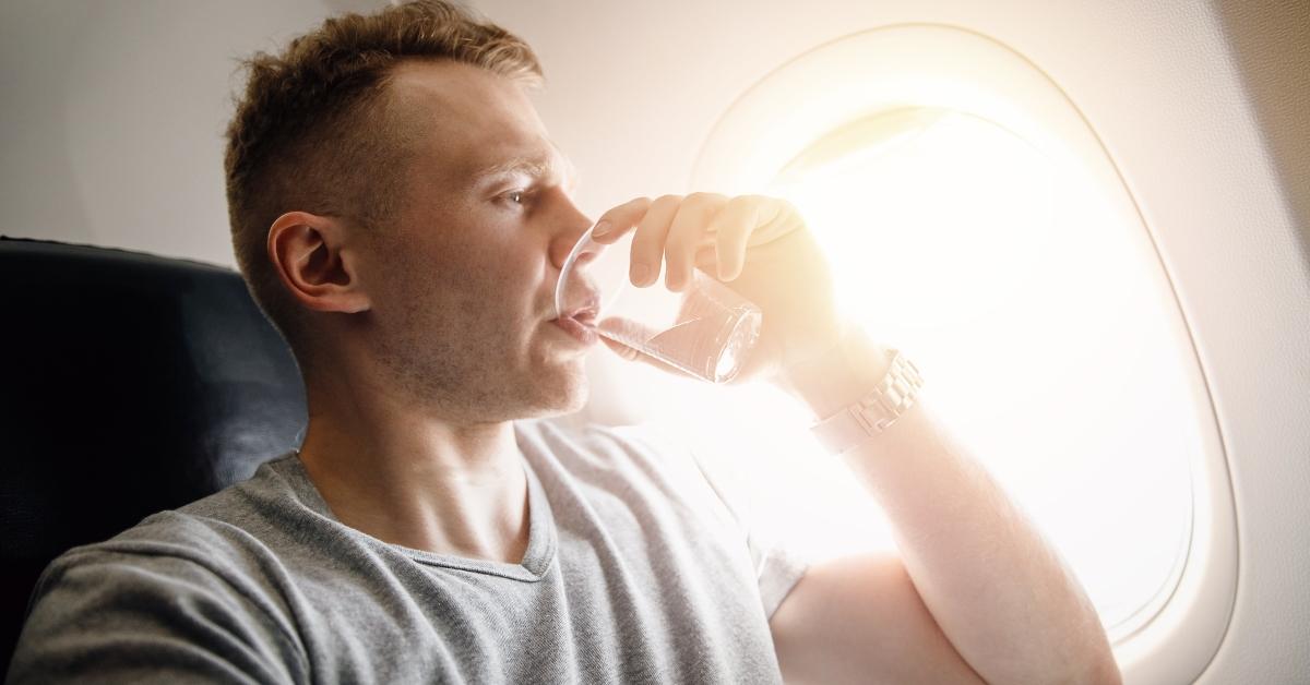 man drinking water afraid to fly on an airplane
